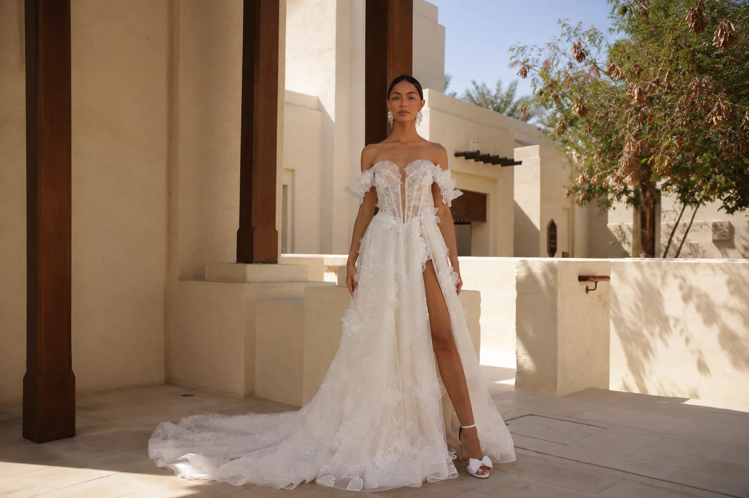 Novia con vestido de tul bordado en un patio de cantera